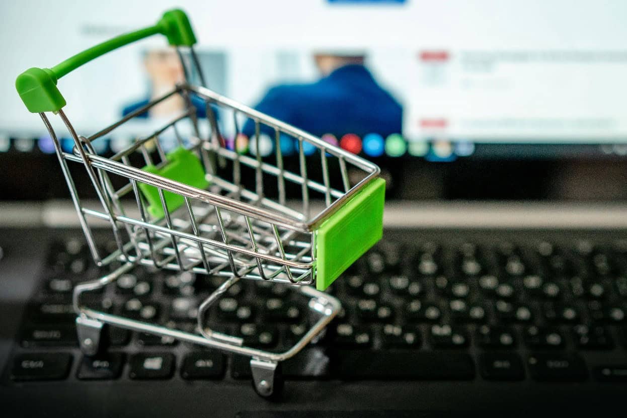 E-commerce shopping cart placed on an open laptop keyboard, symbolizing online retail and digital shopping experiences.